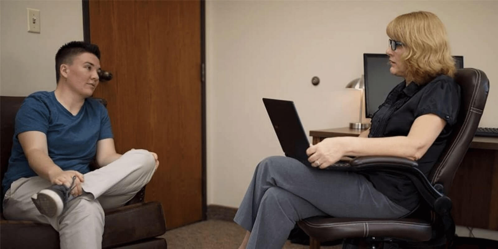 therapist having conversation with a patient in an office