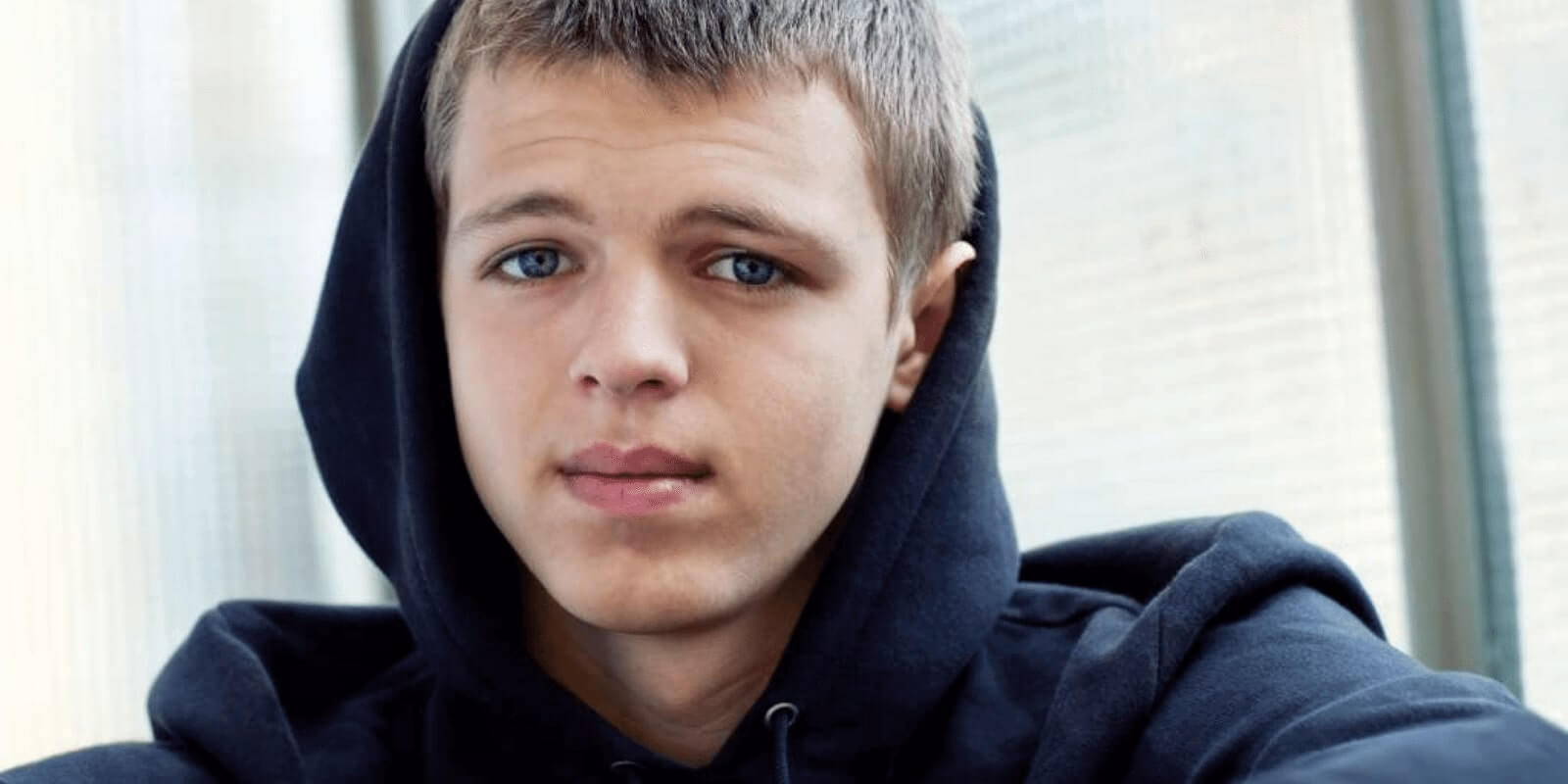 Teen boy wearing a hoody staring at the camera