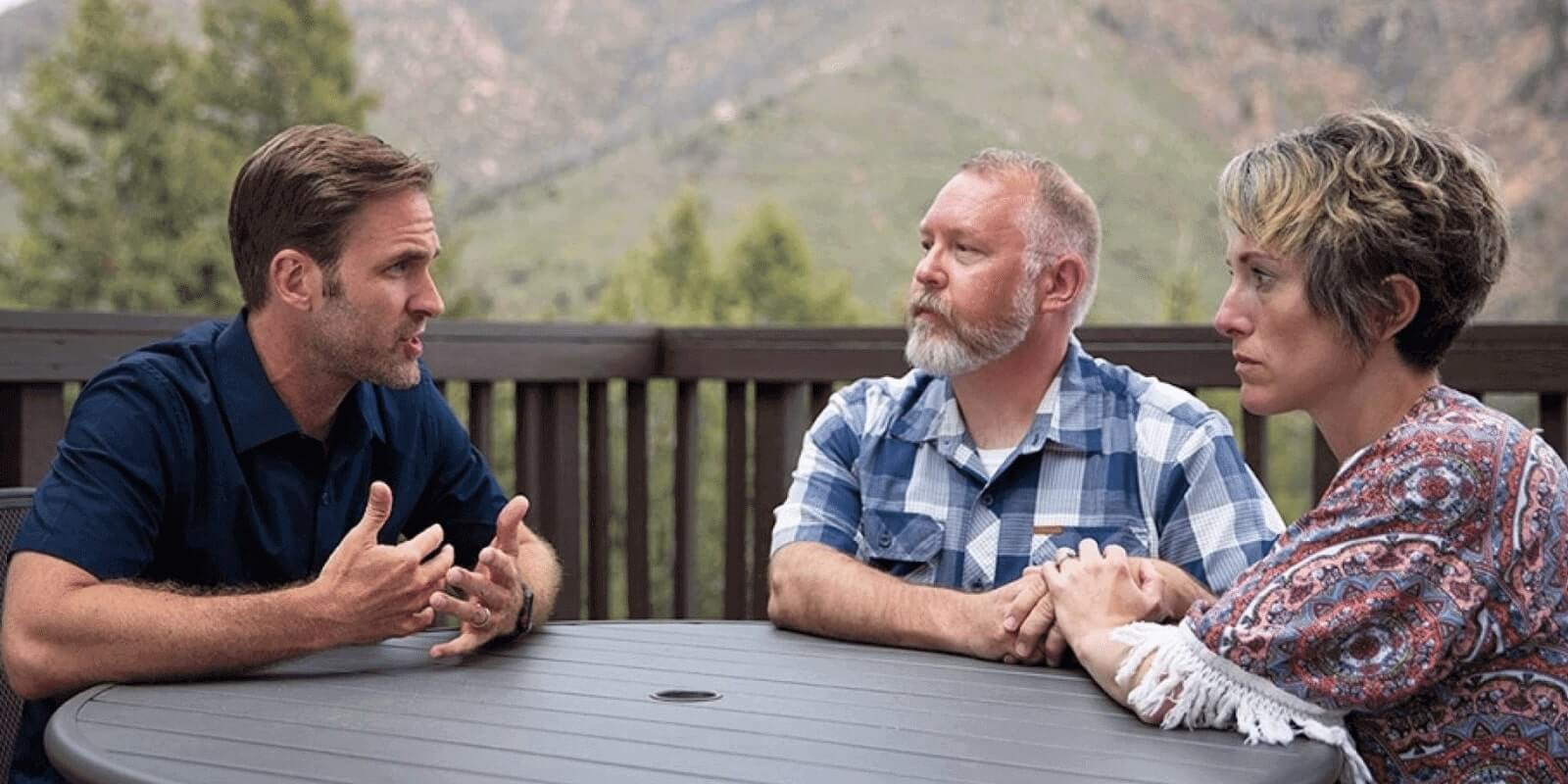 Parents talking to the therapist in a terrace with a mountain view