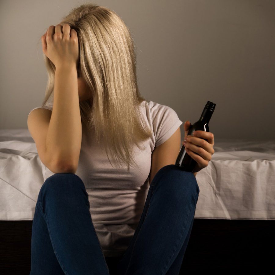 teen holding bottle looking stressed