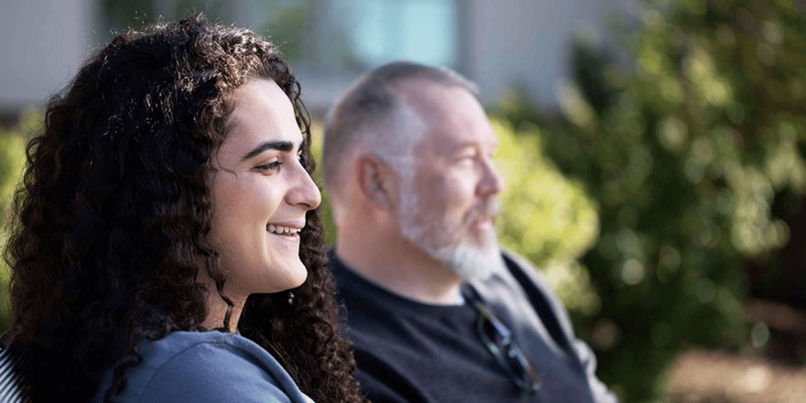 A teen smiling at something with her dad