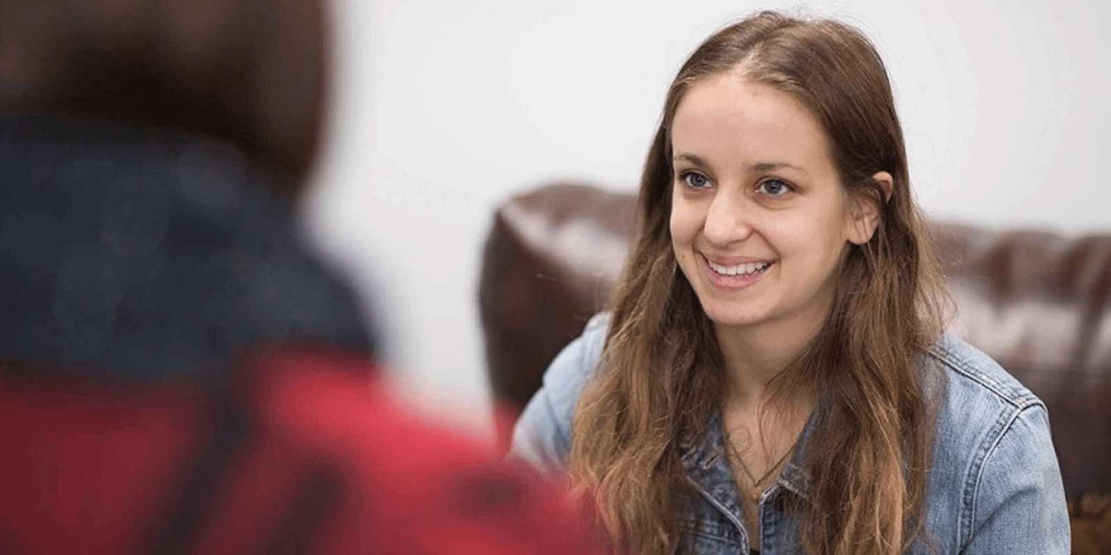 A teen girl smiling at the therapist in front