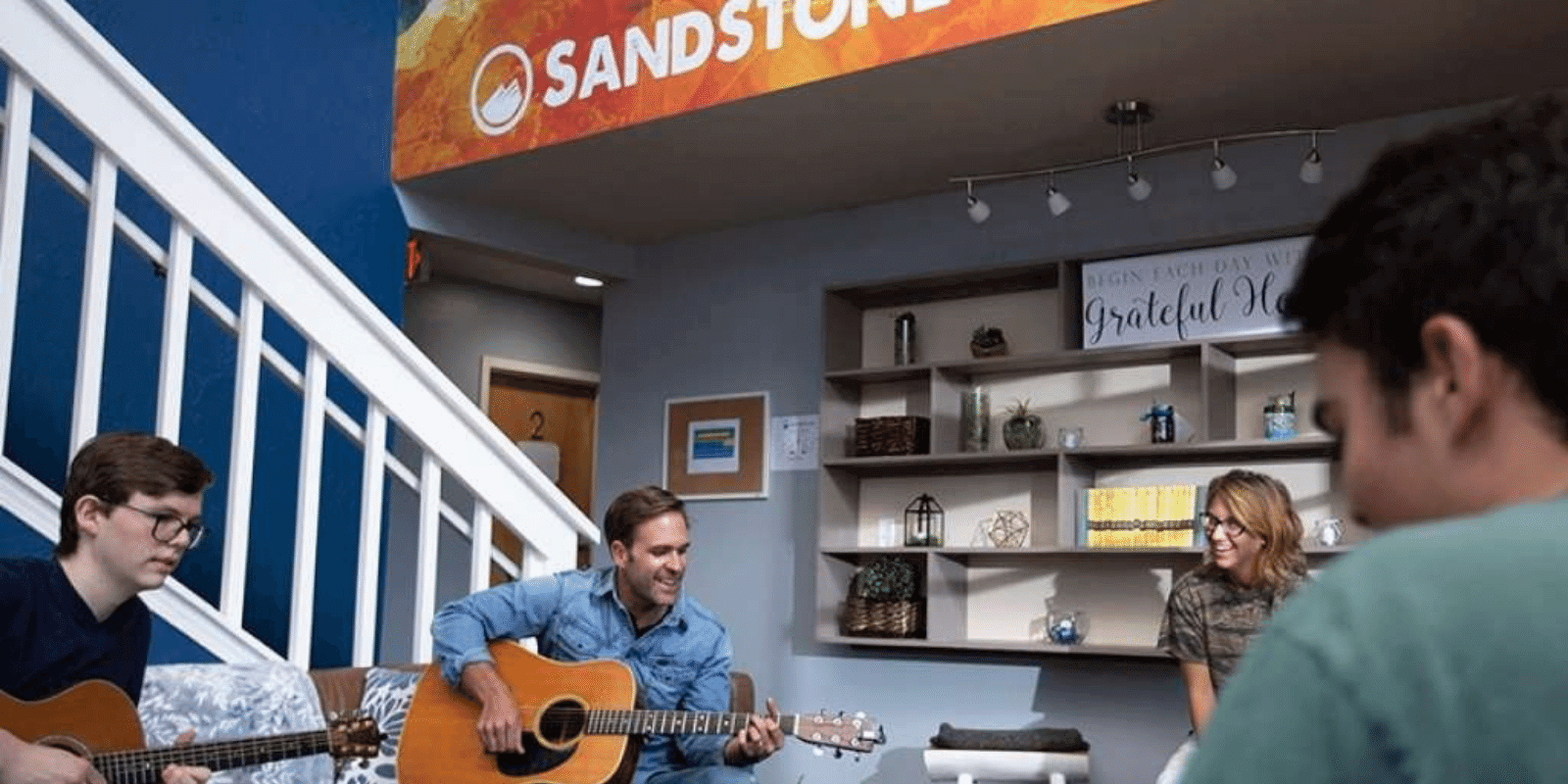 Teens doing music therapy session with a guitar