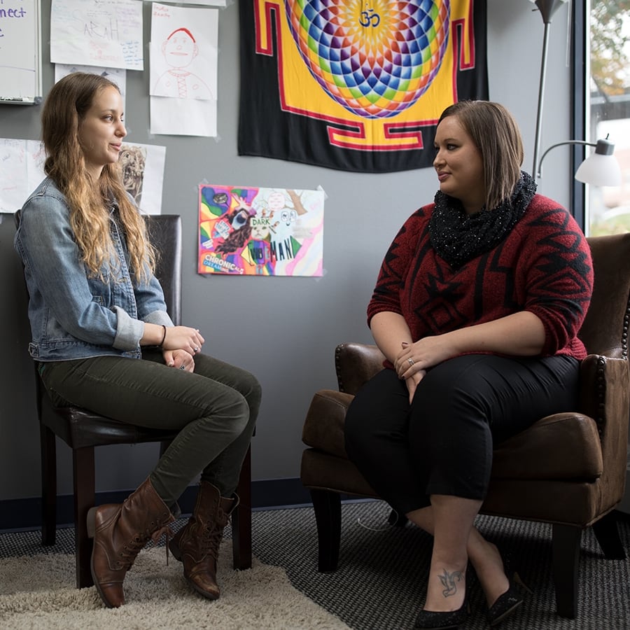 two young adults talking in an office