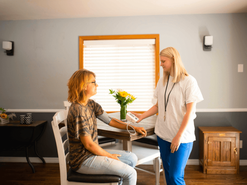 A teen getting her blood pressure measured by a clinician