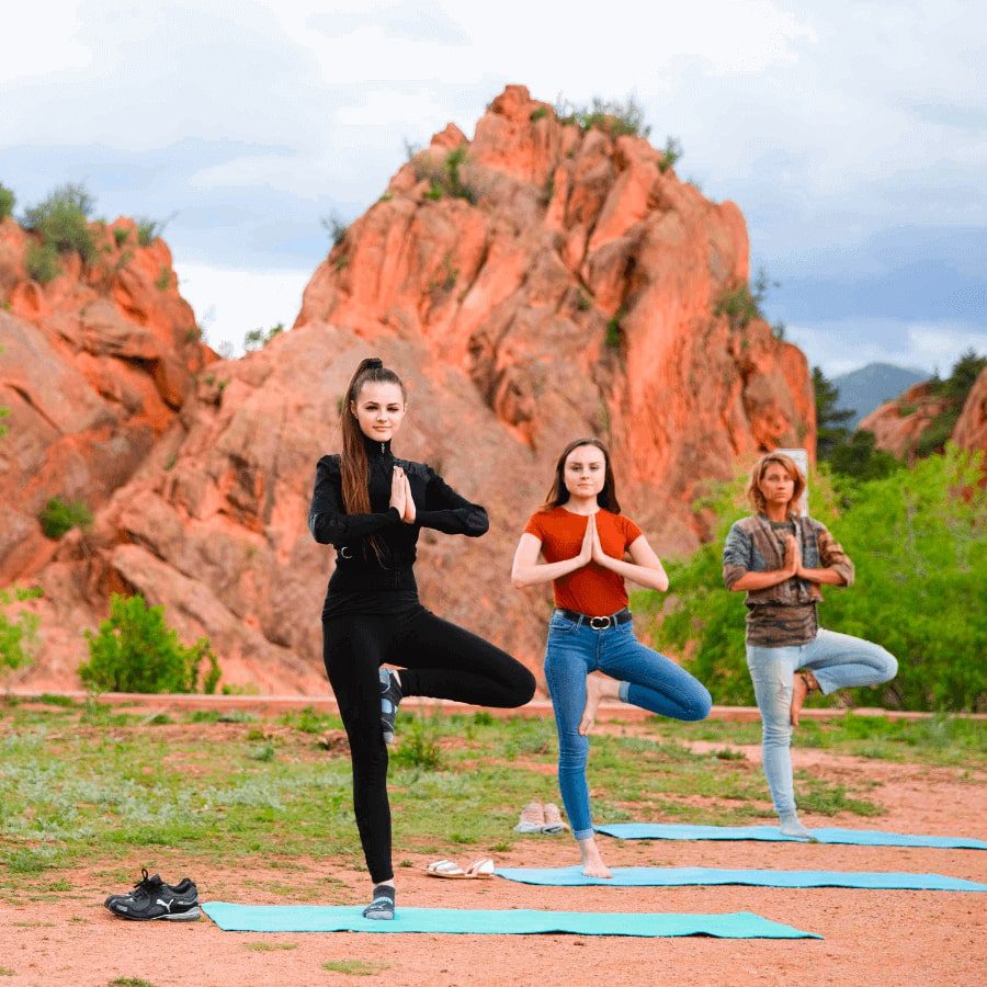 Group of teens doing yoga in the mountain
