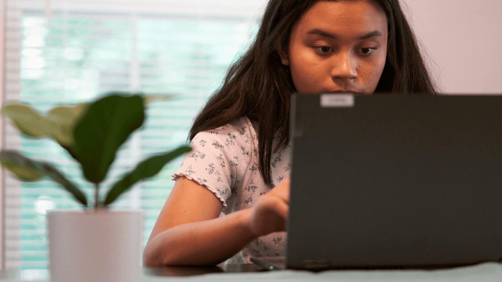 A teen looking at the laptop