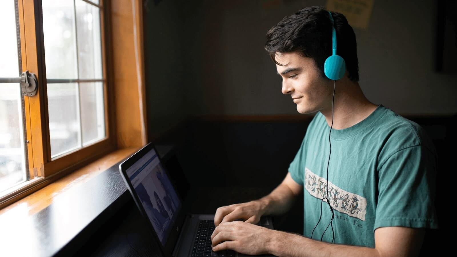 A male young adult participating in virtual IOP with her laptop