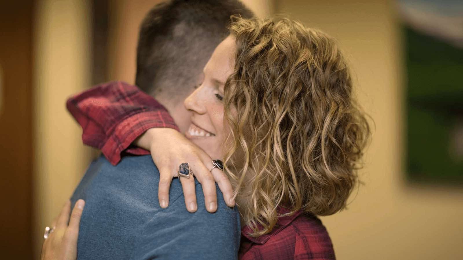 two people hugging in therapy