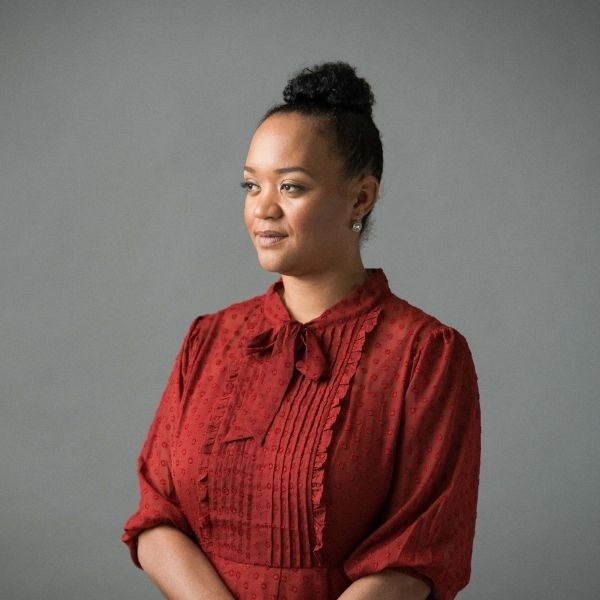 Black woman looking out on a blank background.