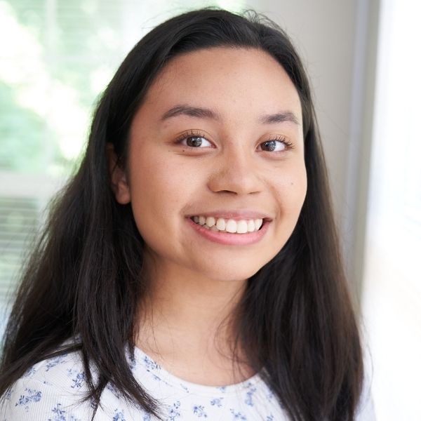 Young teenage girl smiling at the camera.