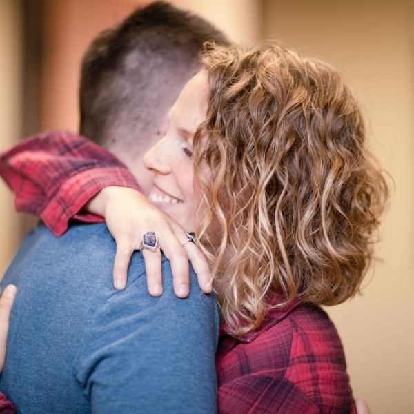 A mother hugging her teenage son.