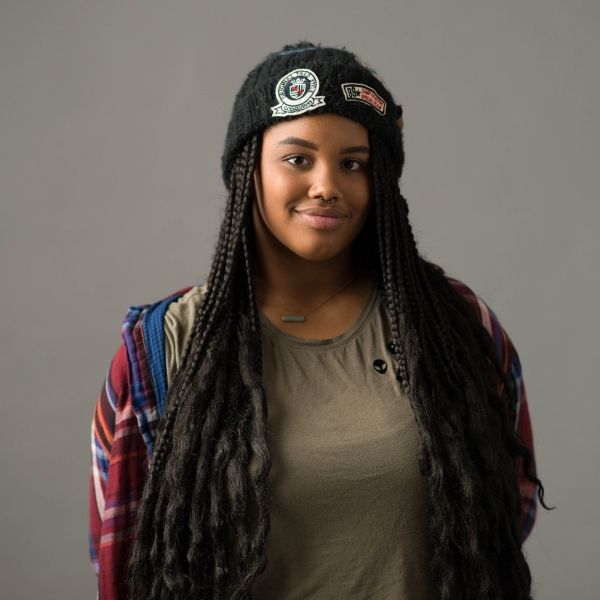 Teenage girl with a beanie on a blank background.