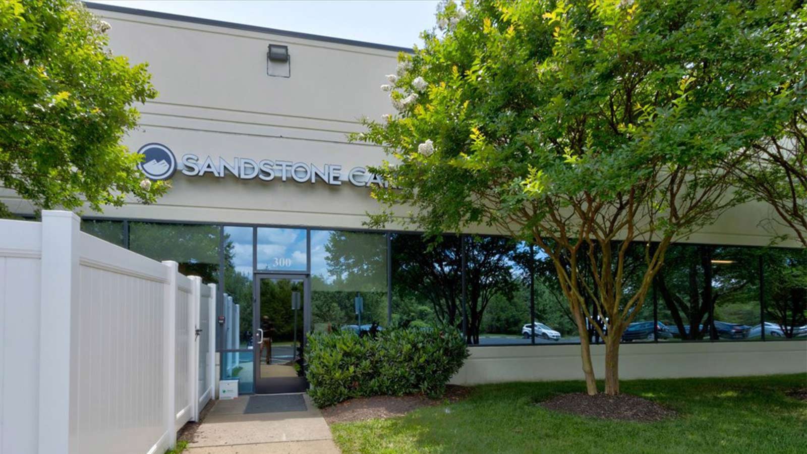 The exterior of Sandstone Cares Virginia Detox center, surrounded by greenery under a clear sky.