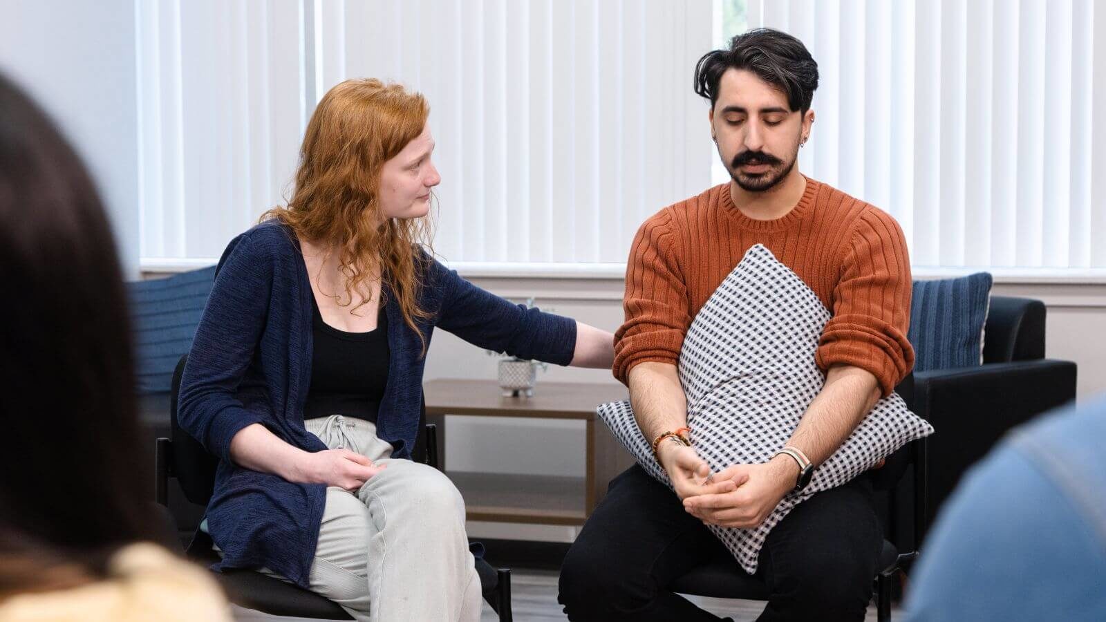 Therapists consoling a client at a group therapy session held in Sandstone Care Virginia Detox Center