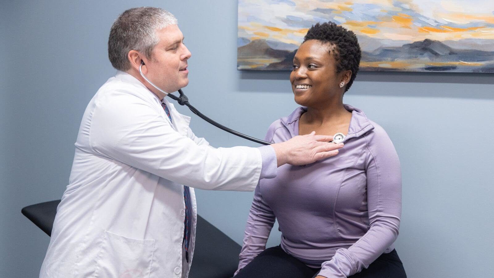 A Clinician examining a smiling female client at Sandstone Care Virginia Detox Center