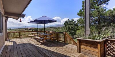 deck with picnic table and mountains in the background
