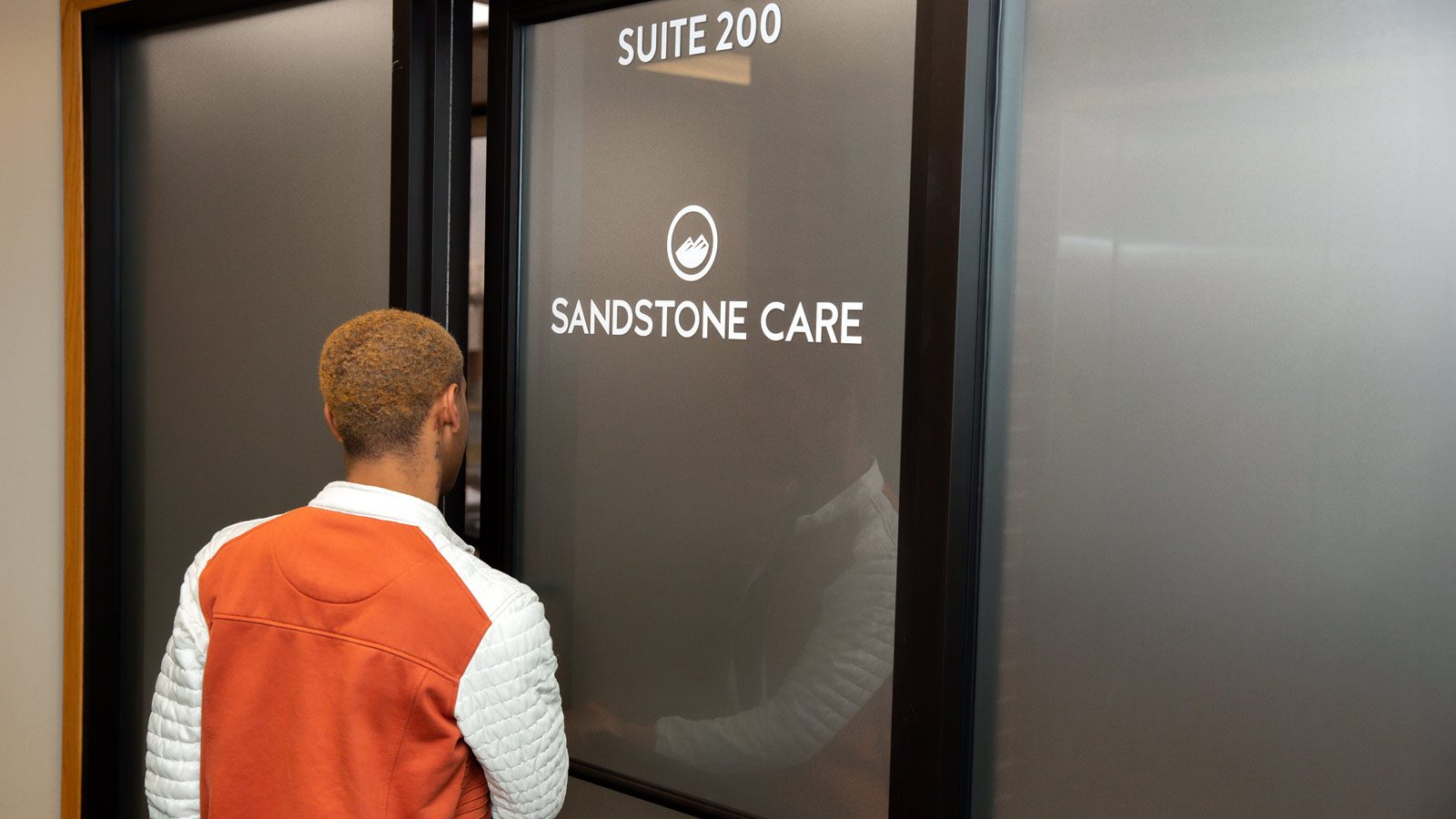 man opening door at sandstone