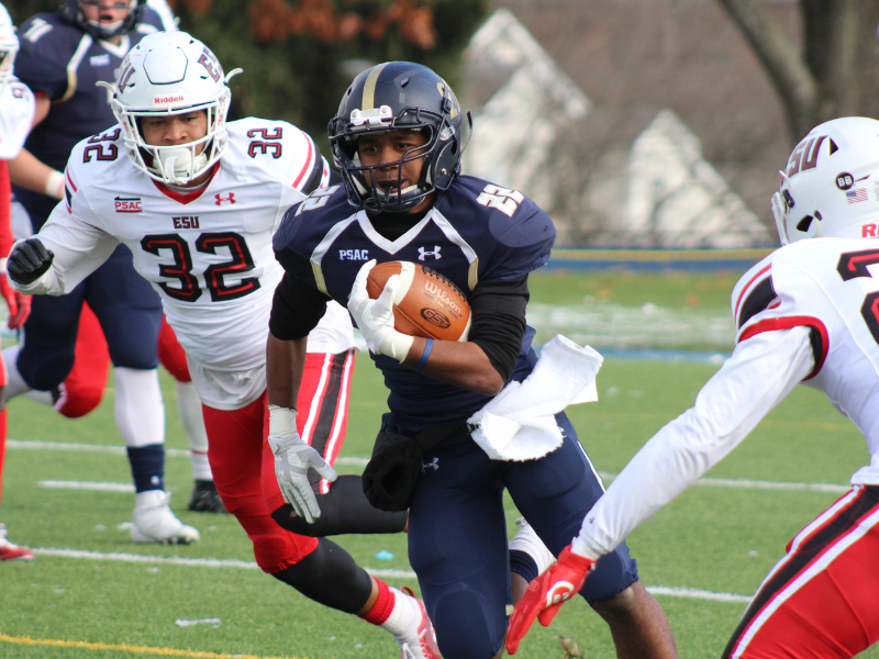 a young high school football player runs with the ball during a game