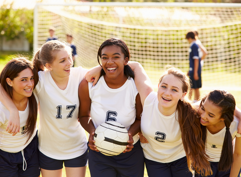 a team of soccer players pose for a photo smiling