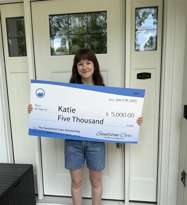 scholarship winner holding a check